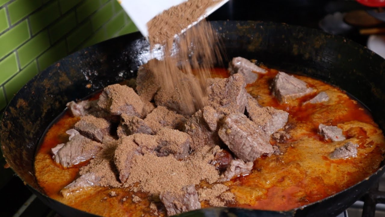 Authentic Indonesian beef rendang recipe simmering low and slow in coconut milk and spices until dark and fragrant