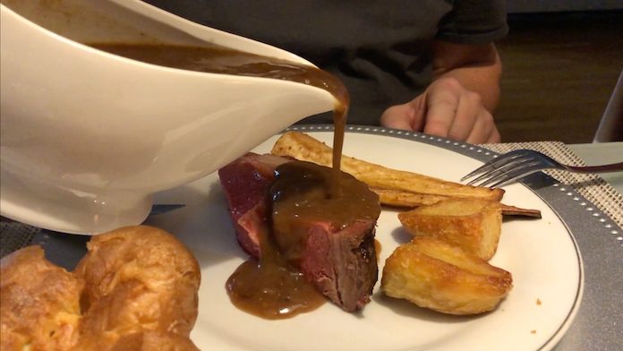 Pouring beef gravy on to the beef
