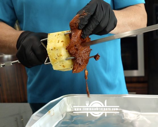 One pineapple slice and marinated pork meat in a spit rod
