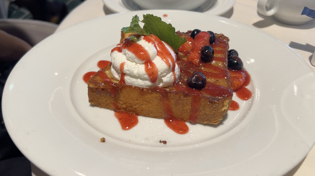Pain Perdu French toast topped with whipped cream and berries