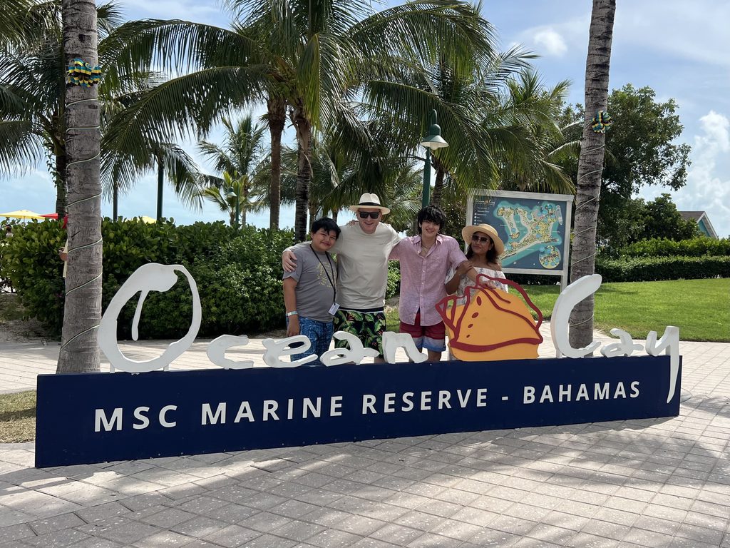 Family standing behind the Ocean Cay MSC Marine Reserve Bahamas sign