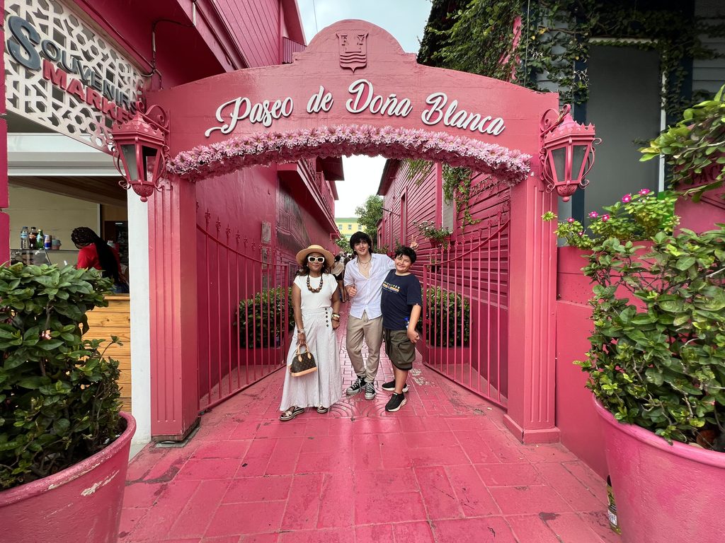 Family walking through the pink Paseo de Dona Blanca archway