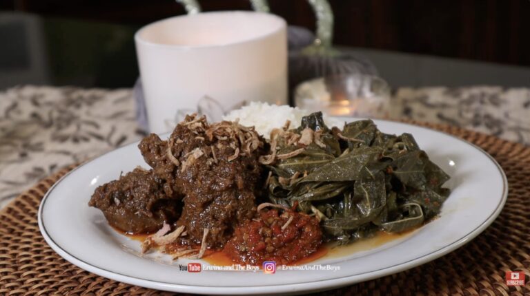 Plated authentic Indonesian beef rendang served with steamed rice, sautéed greens, and sambal, garnished with crispy fried shallots