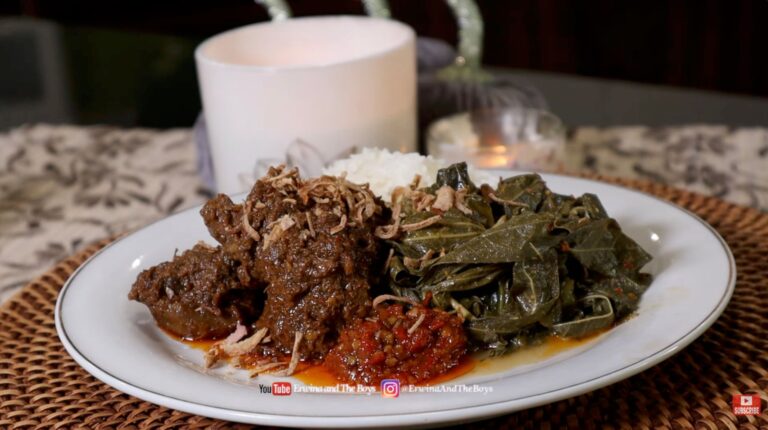 Plated authentic Indonesian beef rendang served with steamed rice, sautéed greens, and sambal, garnished with crispy fried shallots